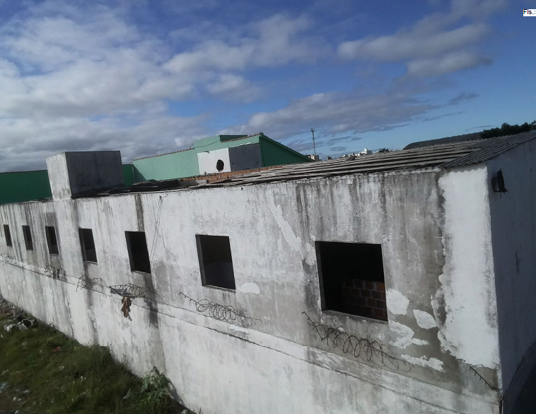 Um terreno com um prédio de alvenaria construído sobre ele, contendo 16 unidades habitacionais